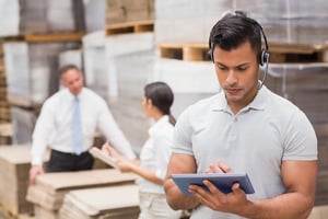 Manager using digital tablet in warehouse